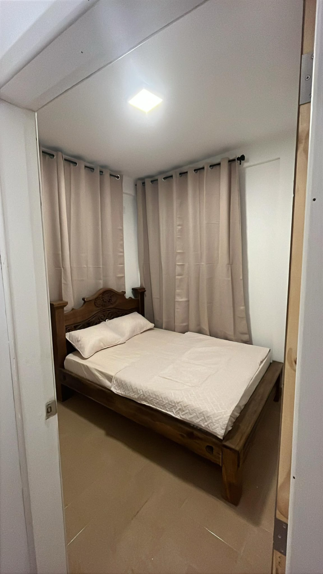Habitación con cama de madera y cortinas