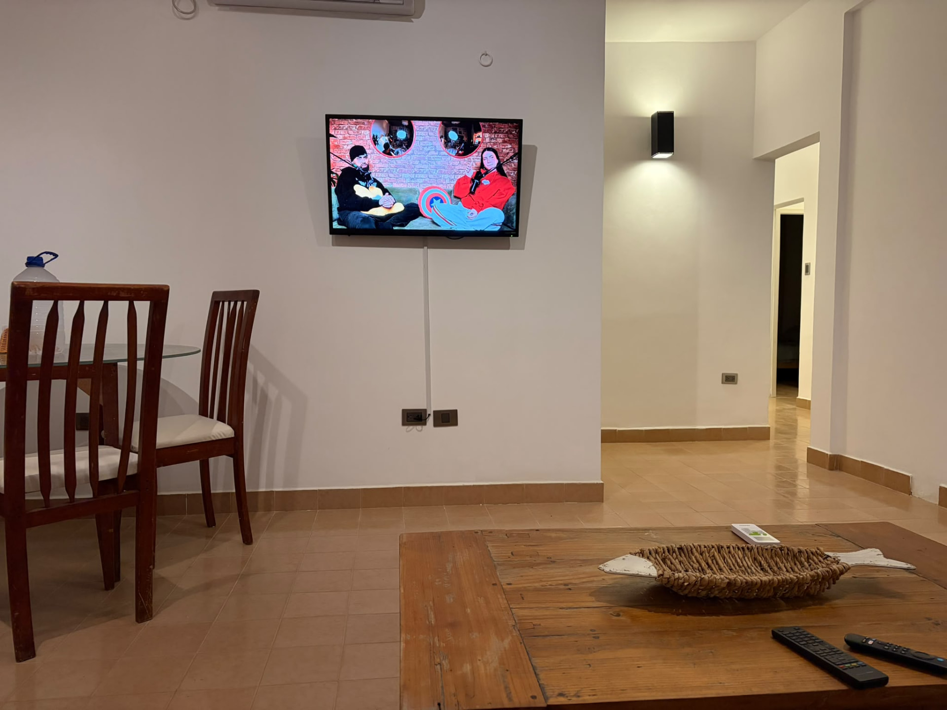 Zona de estar con televisor y comedor